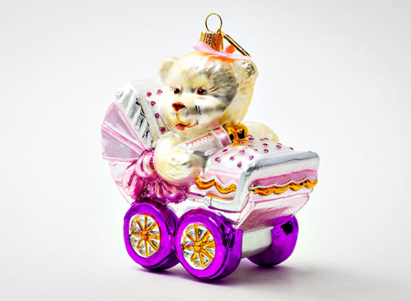 Christmas tree toy Teddy bear in a pink baby stroller